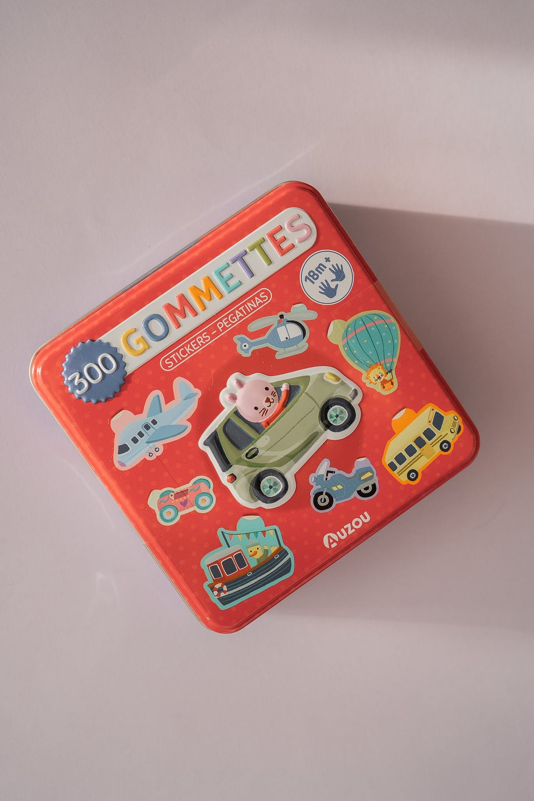 Boîte en métal remplie de gommettes sous le thème des transports de Auzou